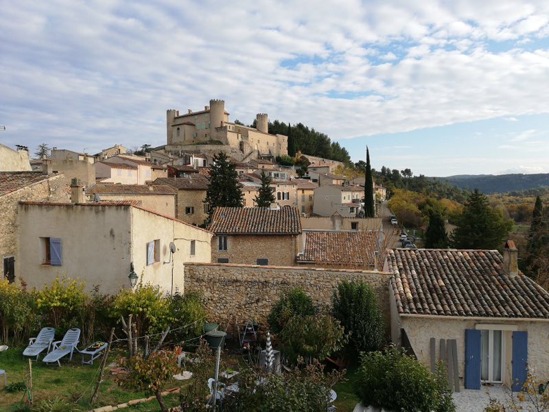 Le village de Mirabeau, ses toits et son château, sous un ciel bleu